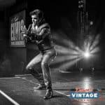 Elvis impersonator JD King on stage in black leather at Dawn's Vintage Do