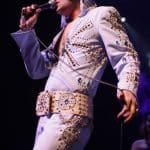 Elvis impersonator JD King on stage in blue Tiffany jumpsuit