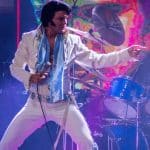 Elvis impersonator JD King on stage in white jumpsuit